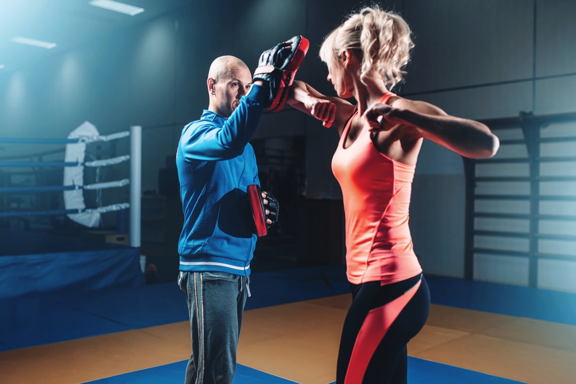 Woman on self defense training with male trainer